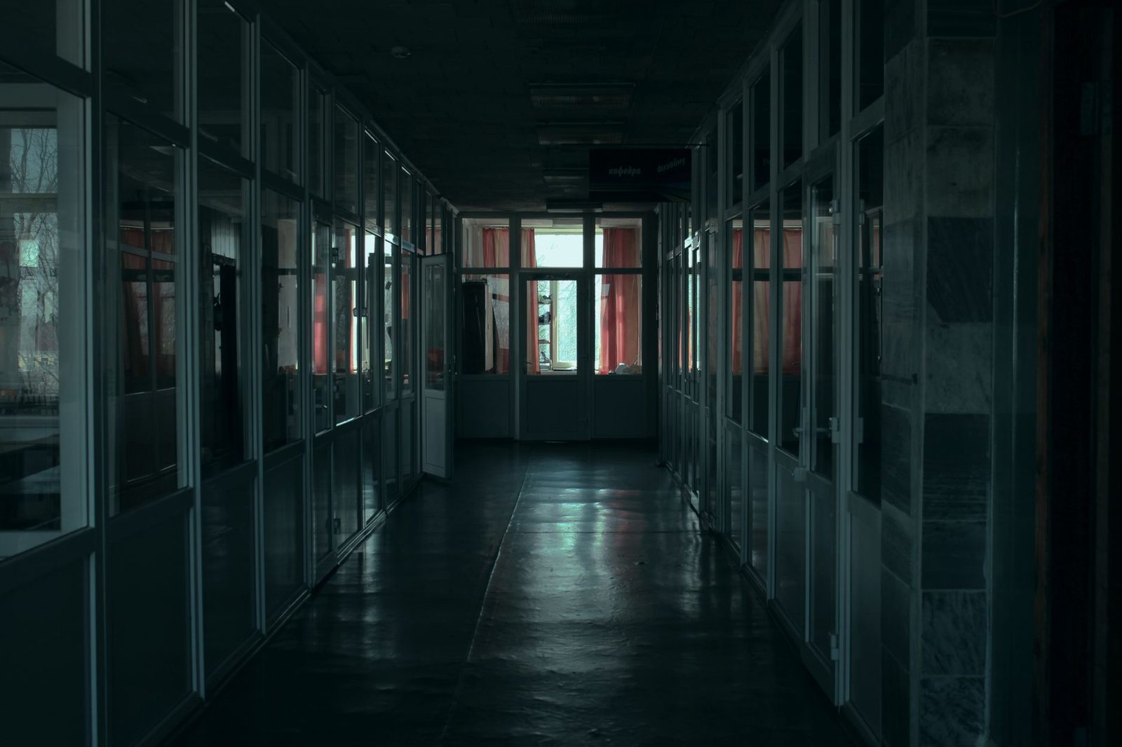 Loş ışıklı, uzun ve boş bir koridor — tekin gelmeyen ev hissinin sade temsili