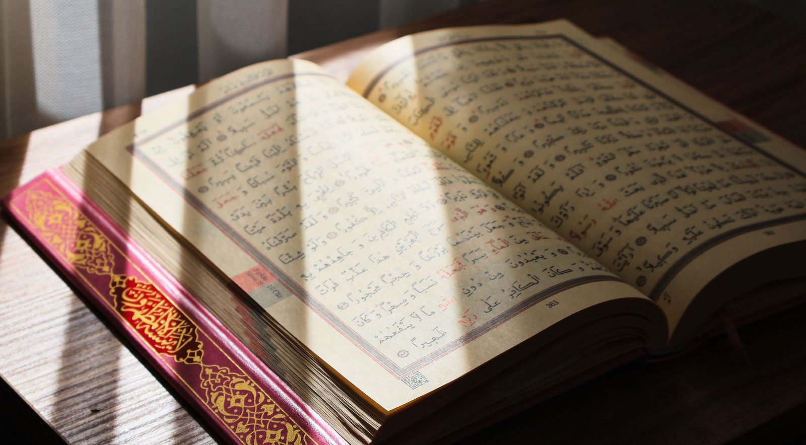 Ahşap bir masada açık duran Kur'an-ı Kerim ve yanında tespih — sabah okumasının huzuru