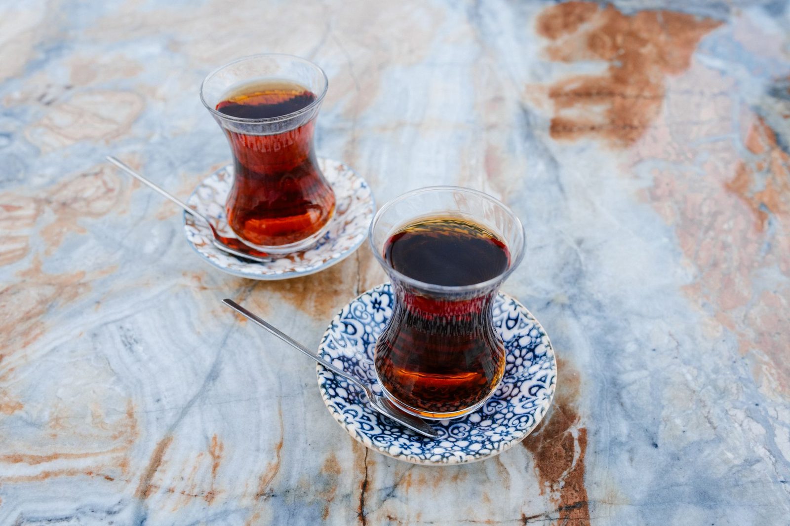 Mermer masada tabakları üzerinde duran iki ince belli çay bardağı