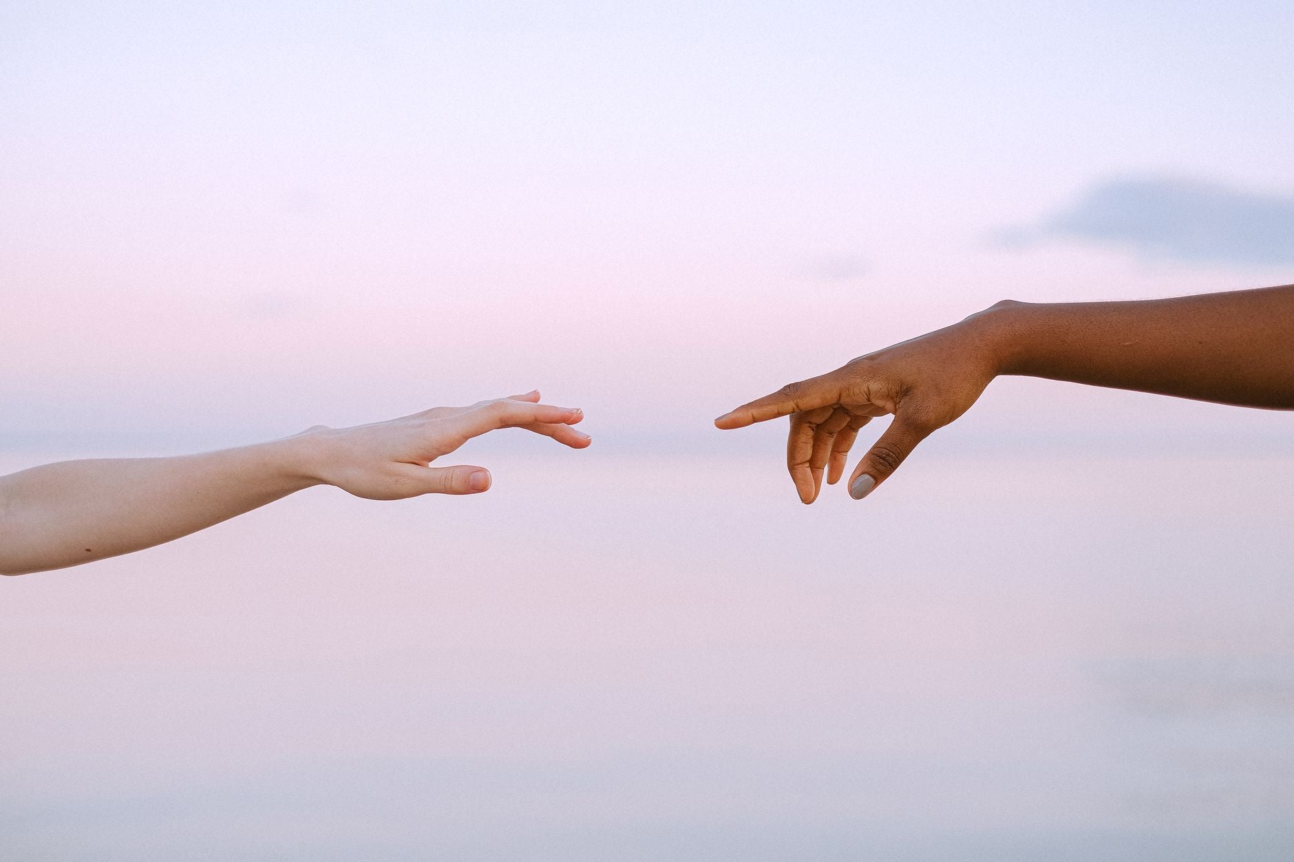 Two hands reaching toward each other, the sustained attention that forms an invisible tie