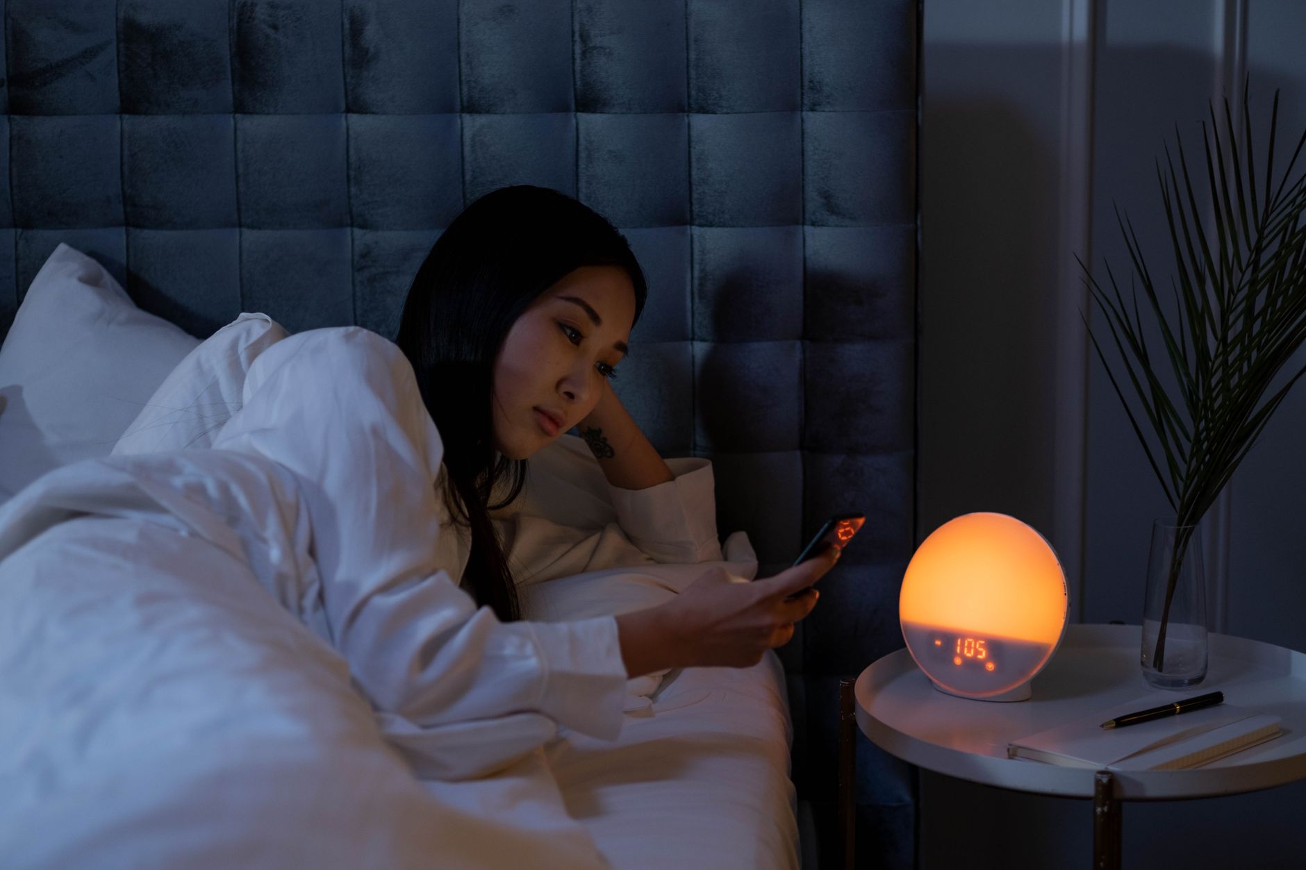 A woman awake at night with sleep disrupted, a common signature of evil-eye anxiety