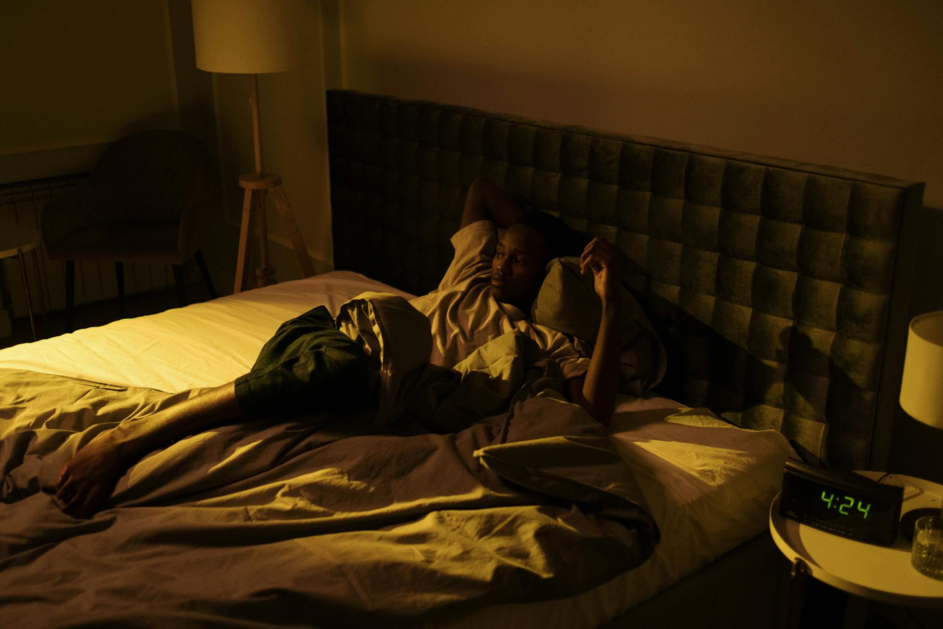 A person lying awake in bed at night — evil-eye symptoms intensify in darkness and solitude