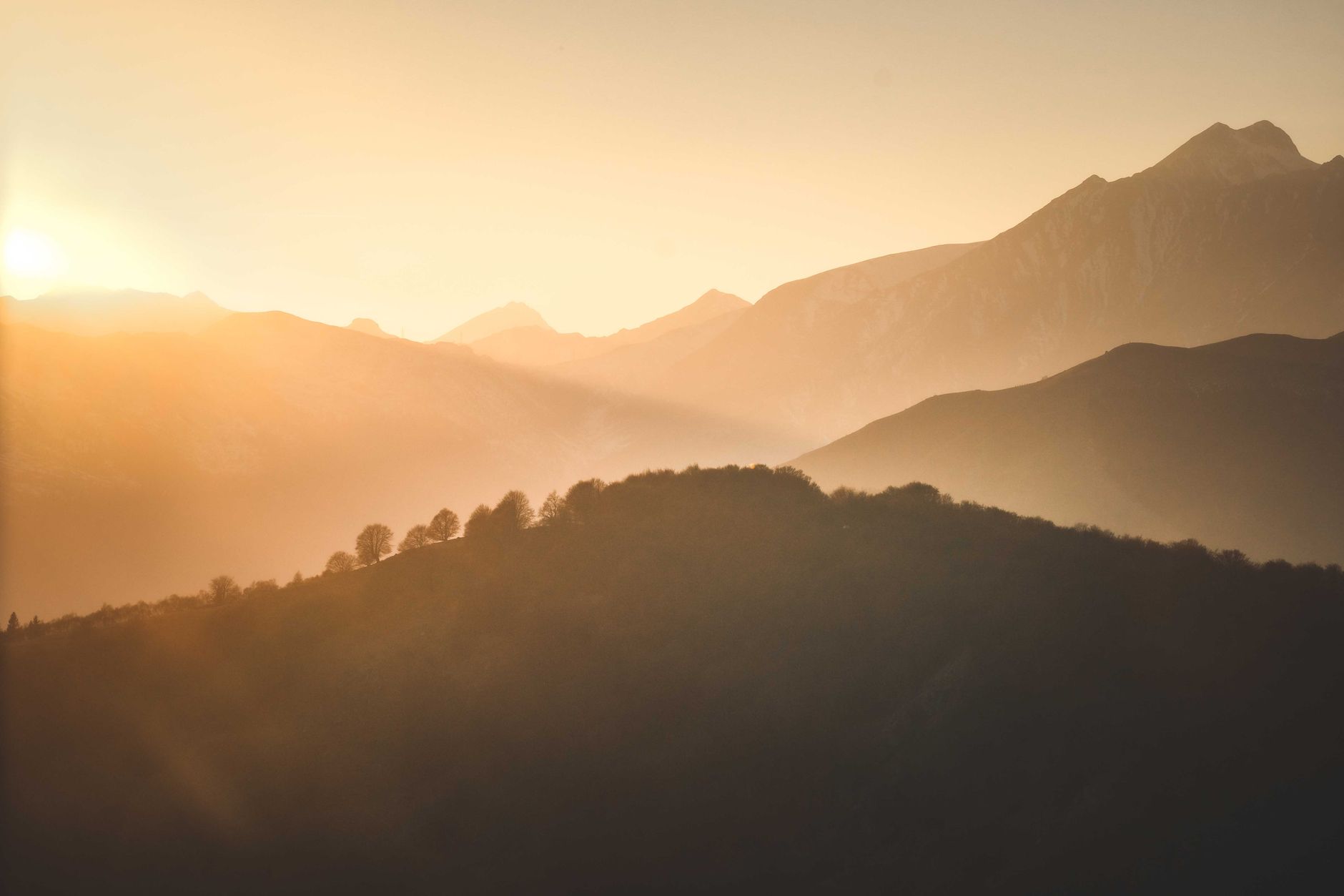 Sun rising over a mountain ridge after dawn — the next stretch of practice opens after the substrate work completes