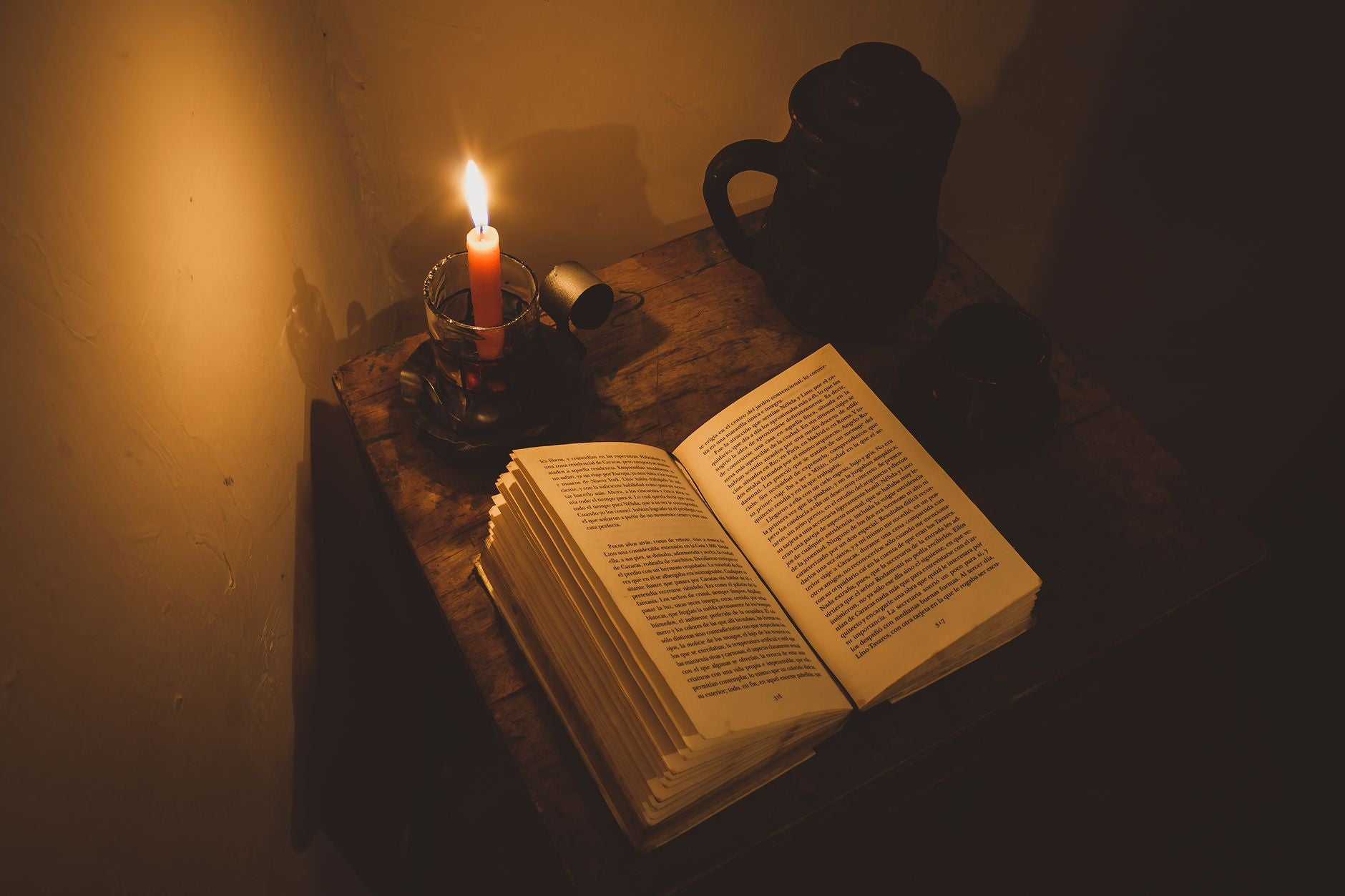 Open Arabic manuscript with calligraphy in candlelight — classical Islamic esoteric textual tradition