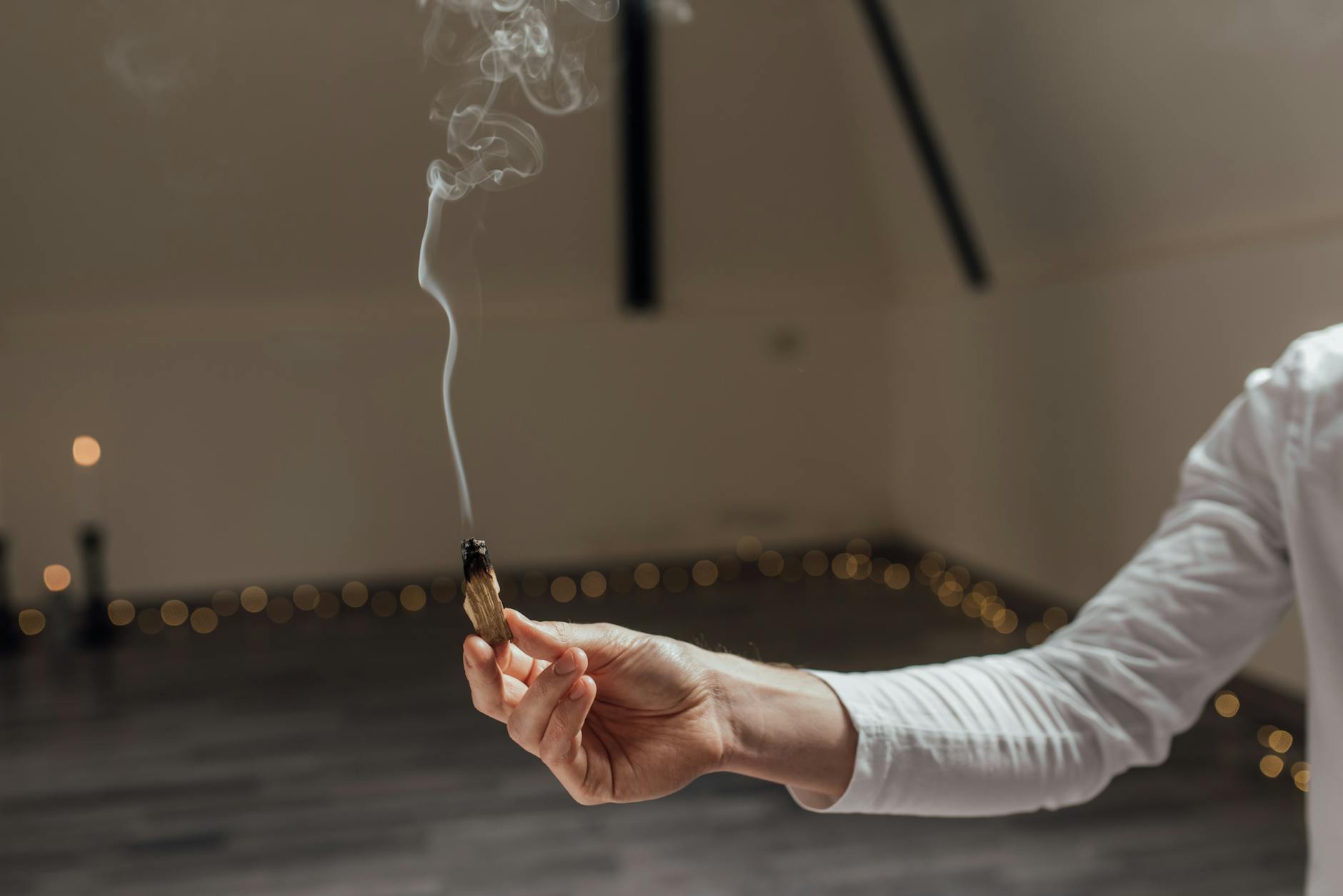 Smoke from burning incense rises from a small clay holder, marking the activation of a consecration ritual
