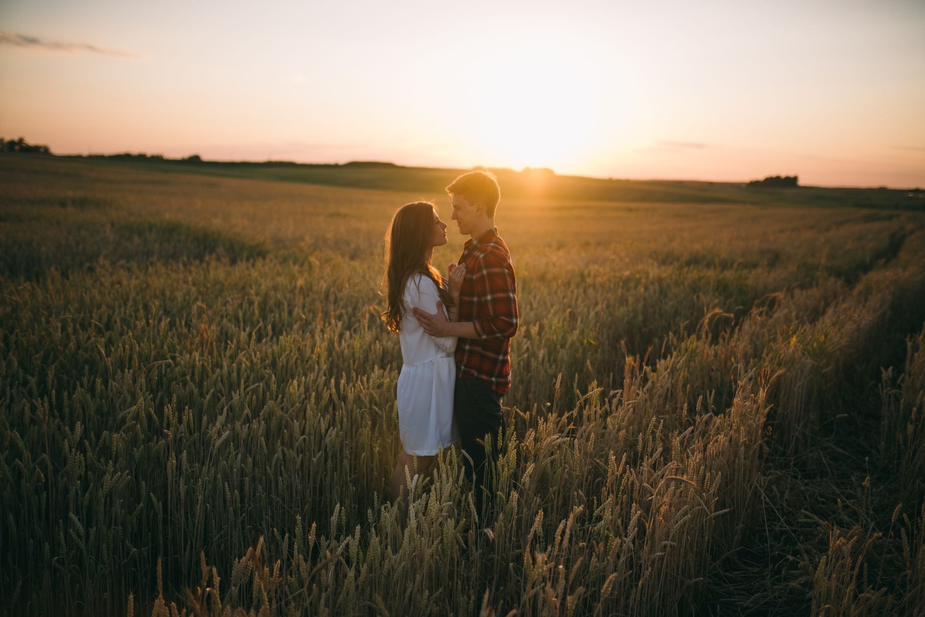 Silhouettes of a couple standing in a sunlit wheat field at golden hour, representing the inner-state alignment behind real compatibility