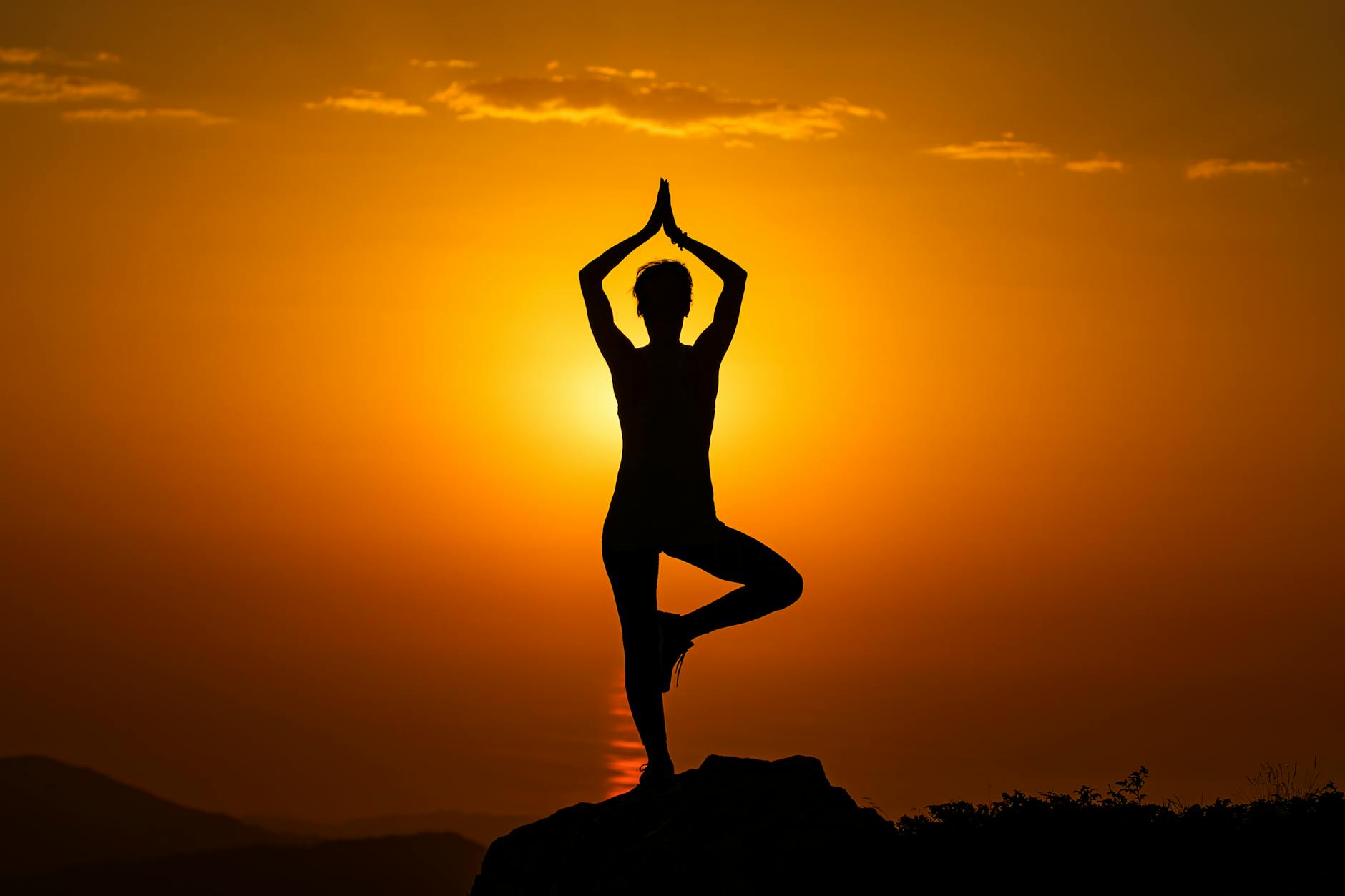 A meditation silhouette at sunset, the practice that awakens Kundalini energy