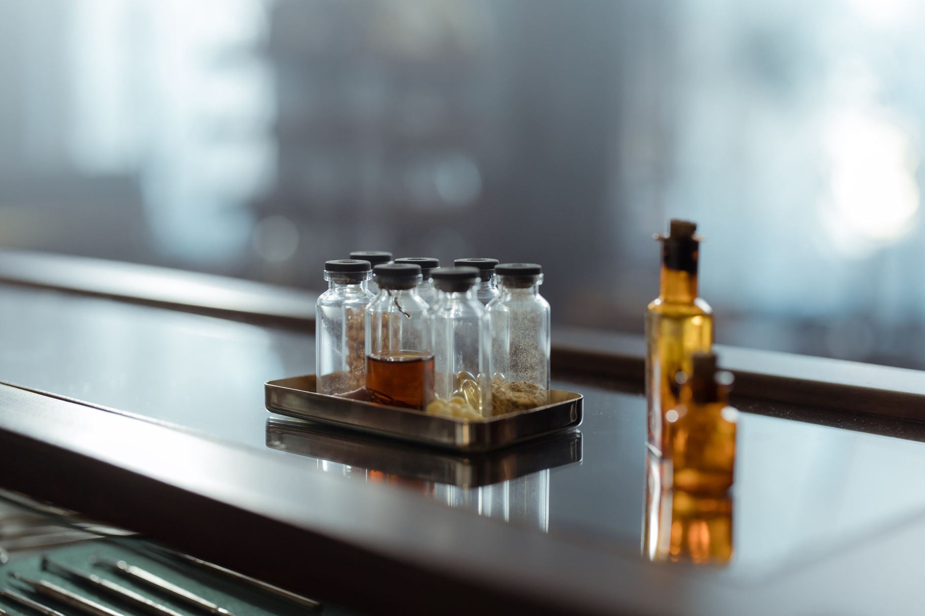 Clear glass vessels on a wooden table, evoking the alchemical vessel as a teaching device