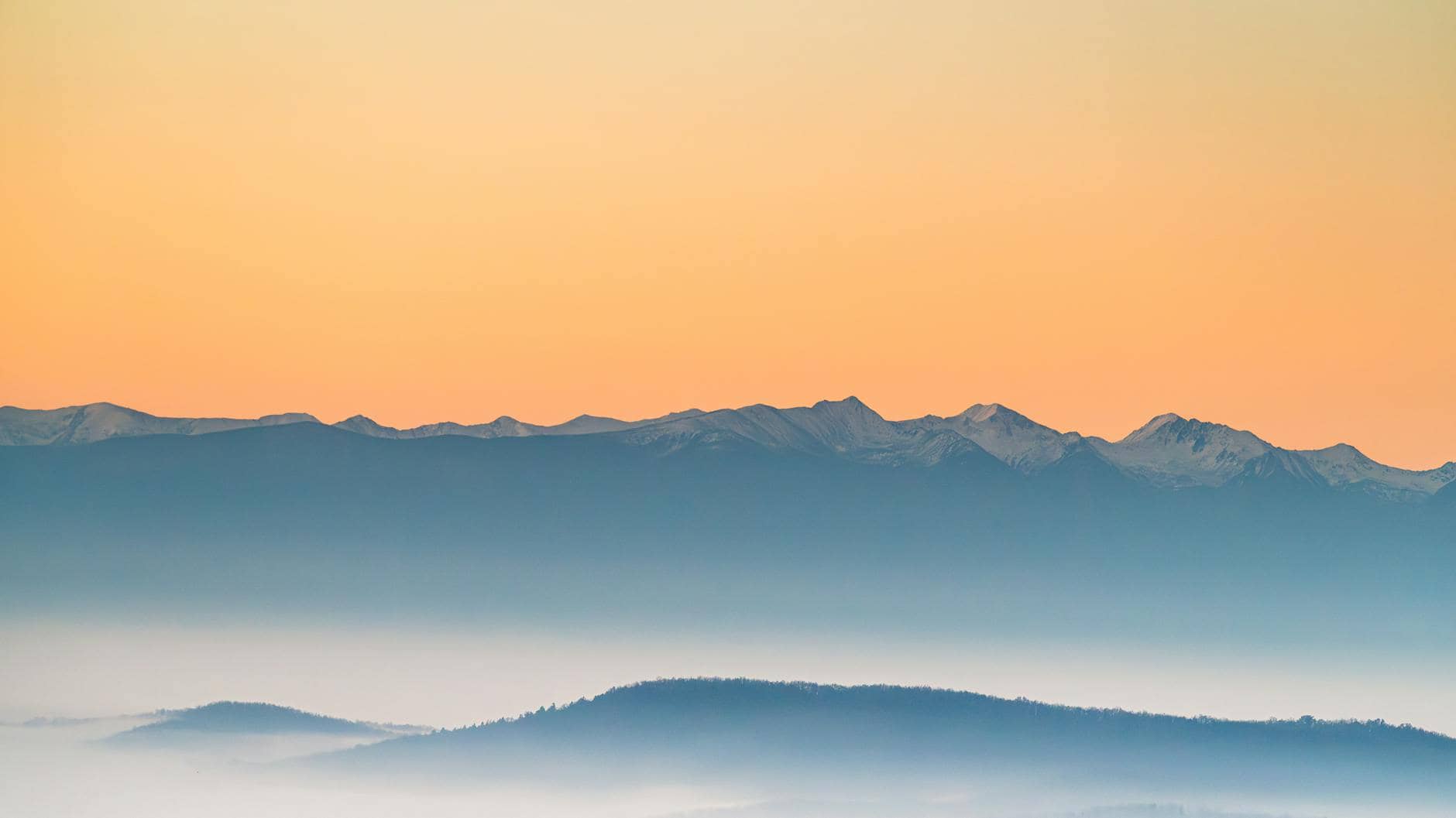 Serene misty mountains catching the first light at sunrise