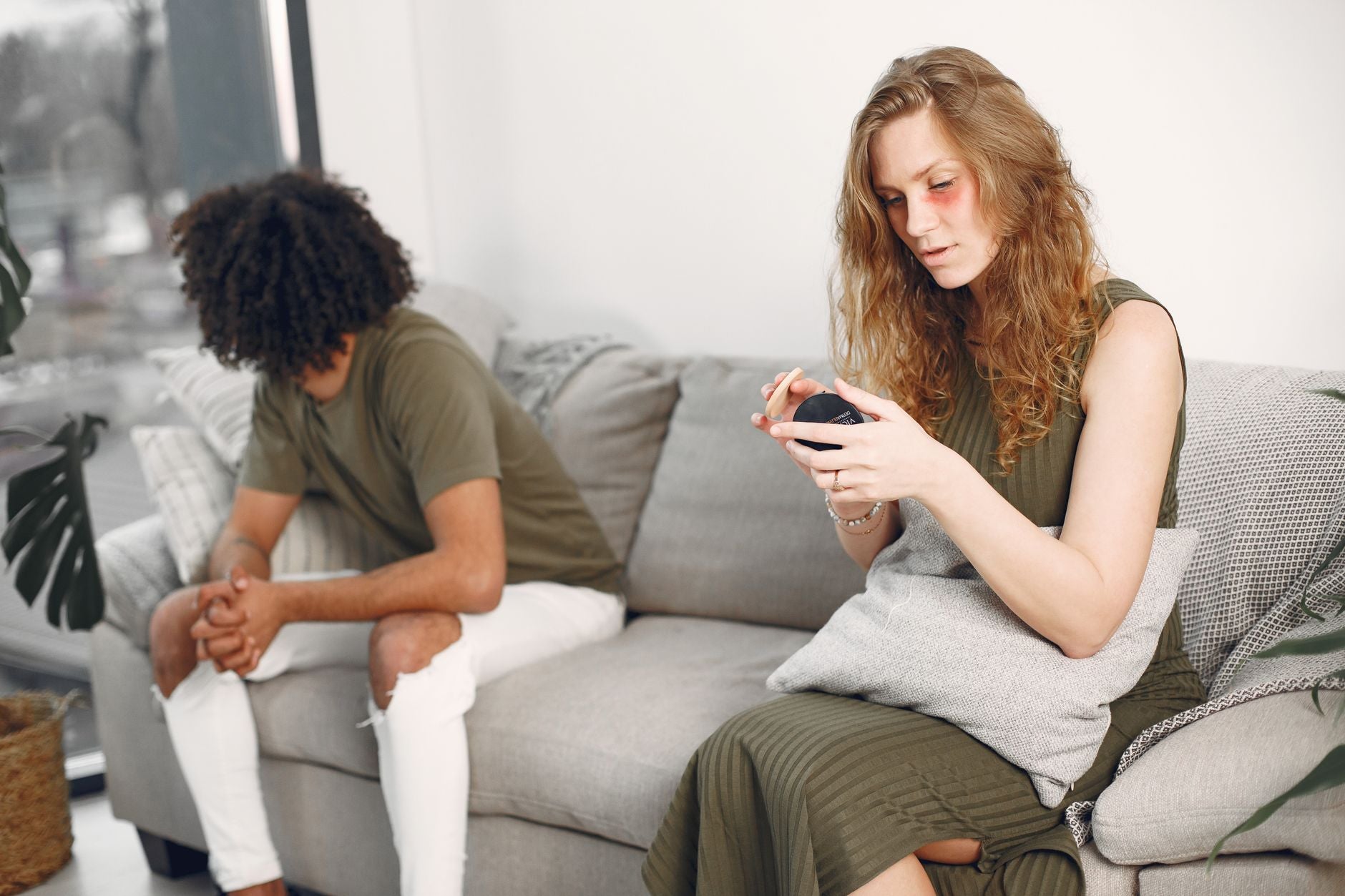 A couple sitting apart on a sofa, each lost in thought, during a tidal trough in the relationship