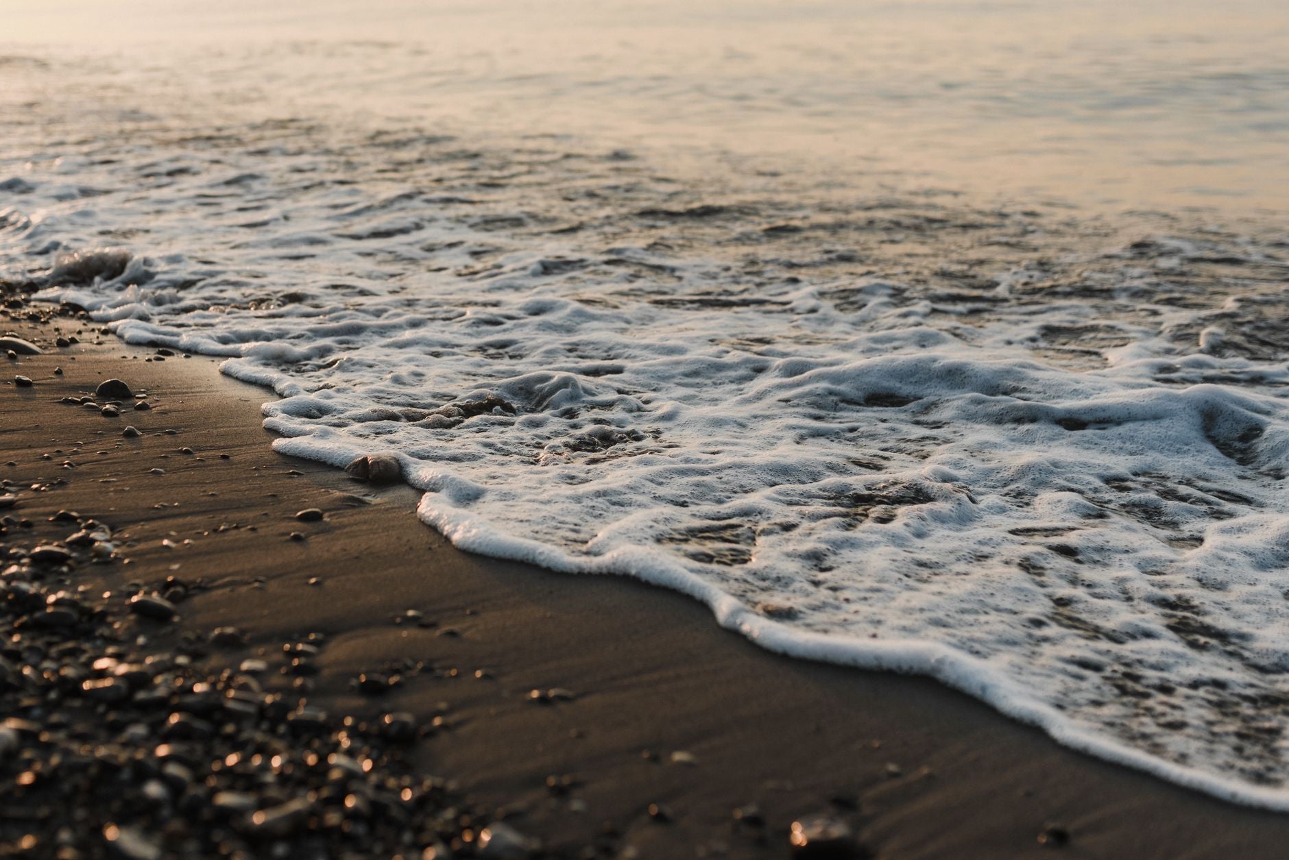 Why Relationships Fail After Initial Intensity — a wave receding from a calm shoreline at dawn, the tidal pattern made visible