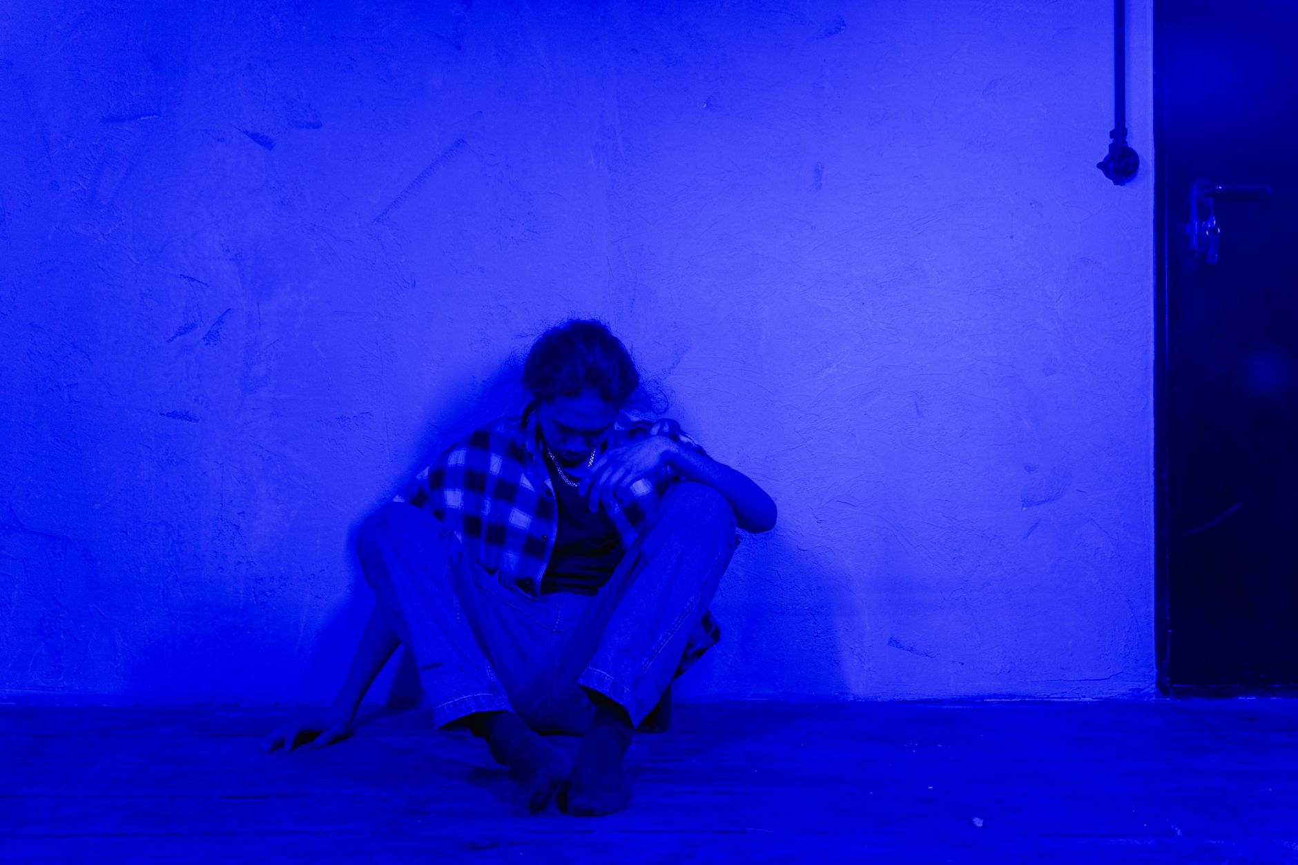 A woman sitting alone in blue light, the body's autonomic nervous system registering disturbance as anxiety