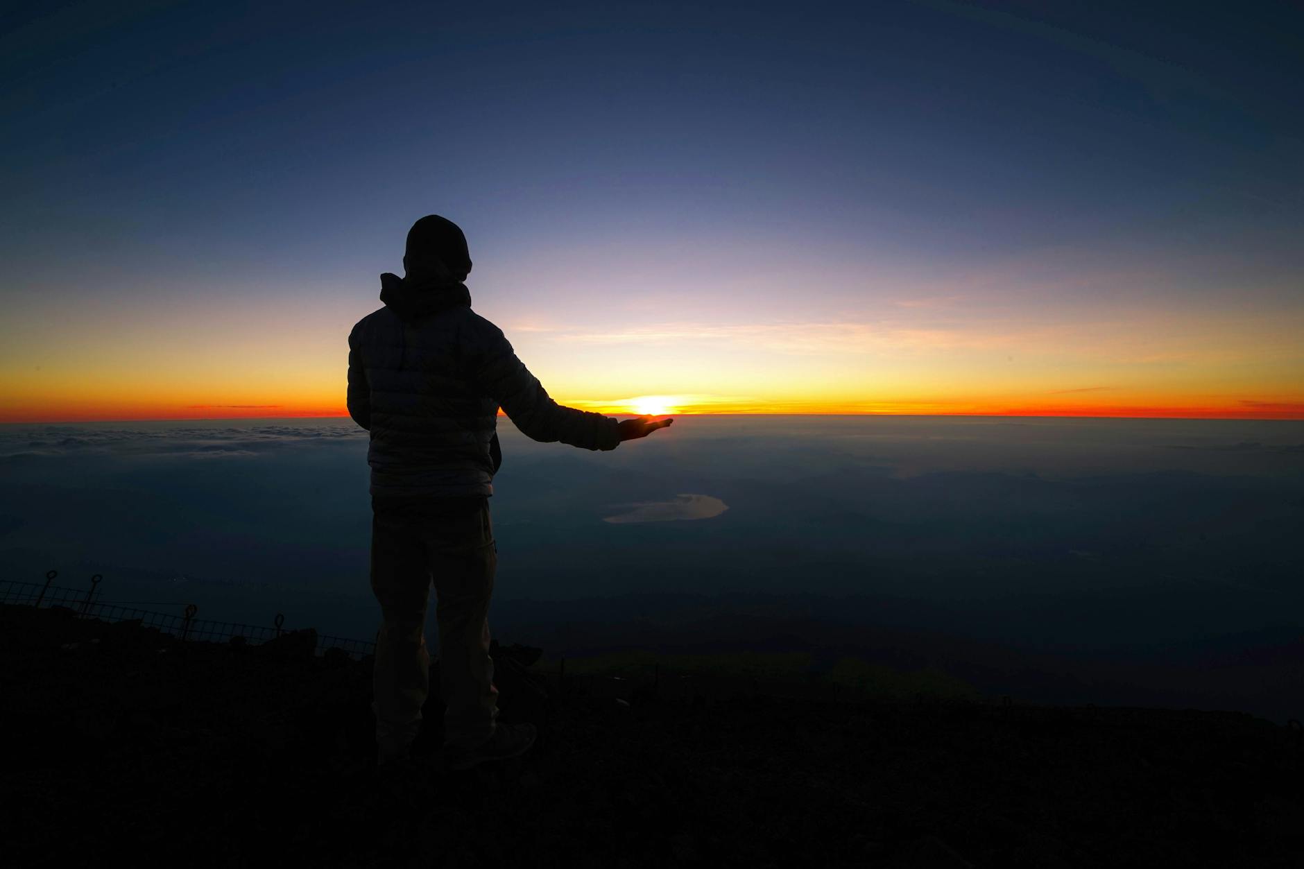 A figure standing on a mountain at sunrise, the higher consciousness Kundalini opens toward