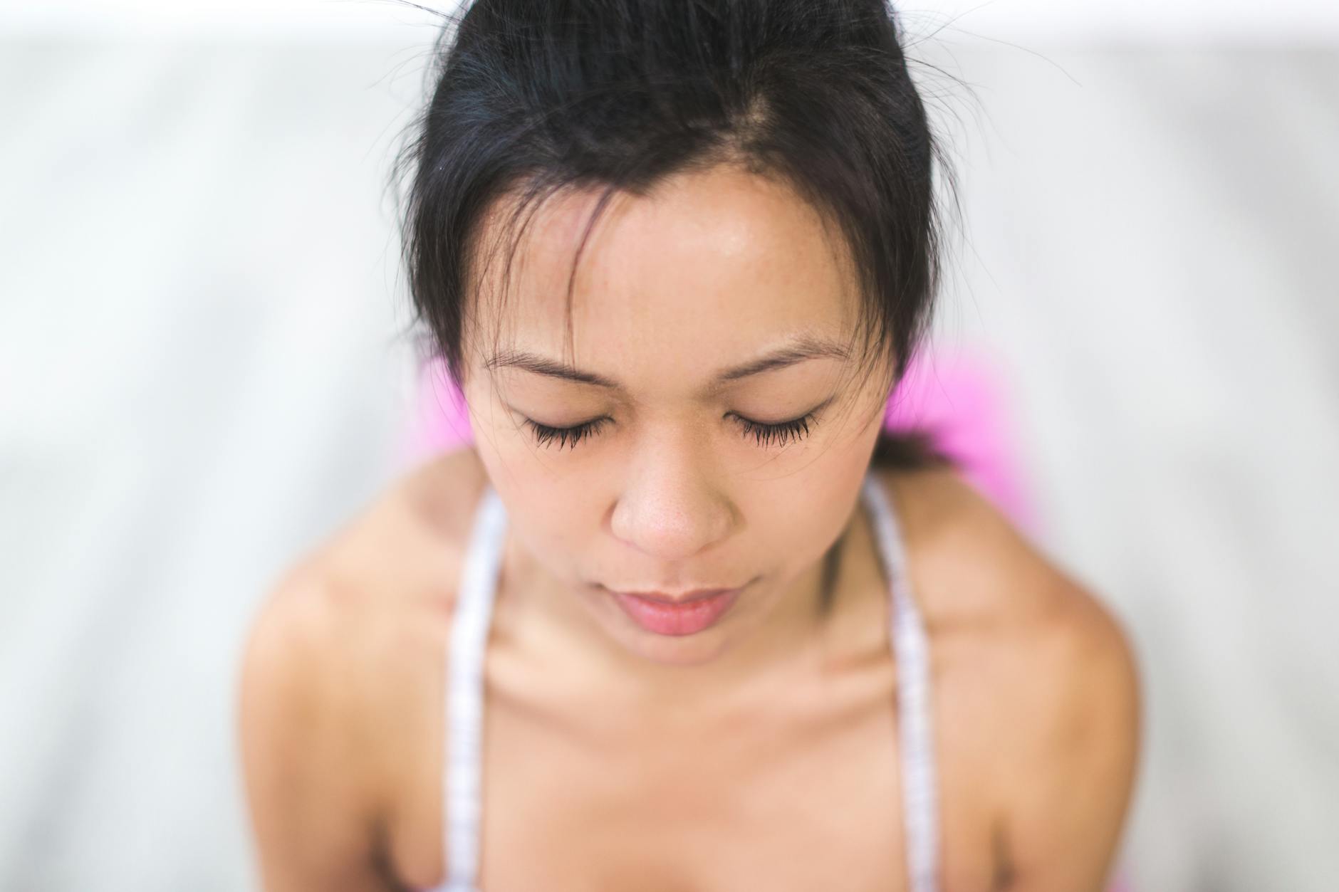 A person with eyes closed in calm focus, attention held steadily on a single object