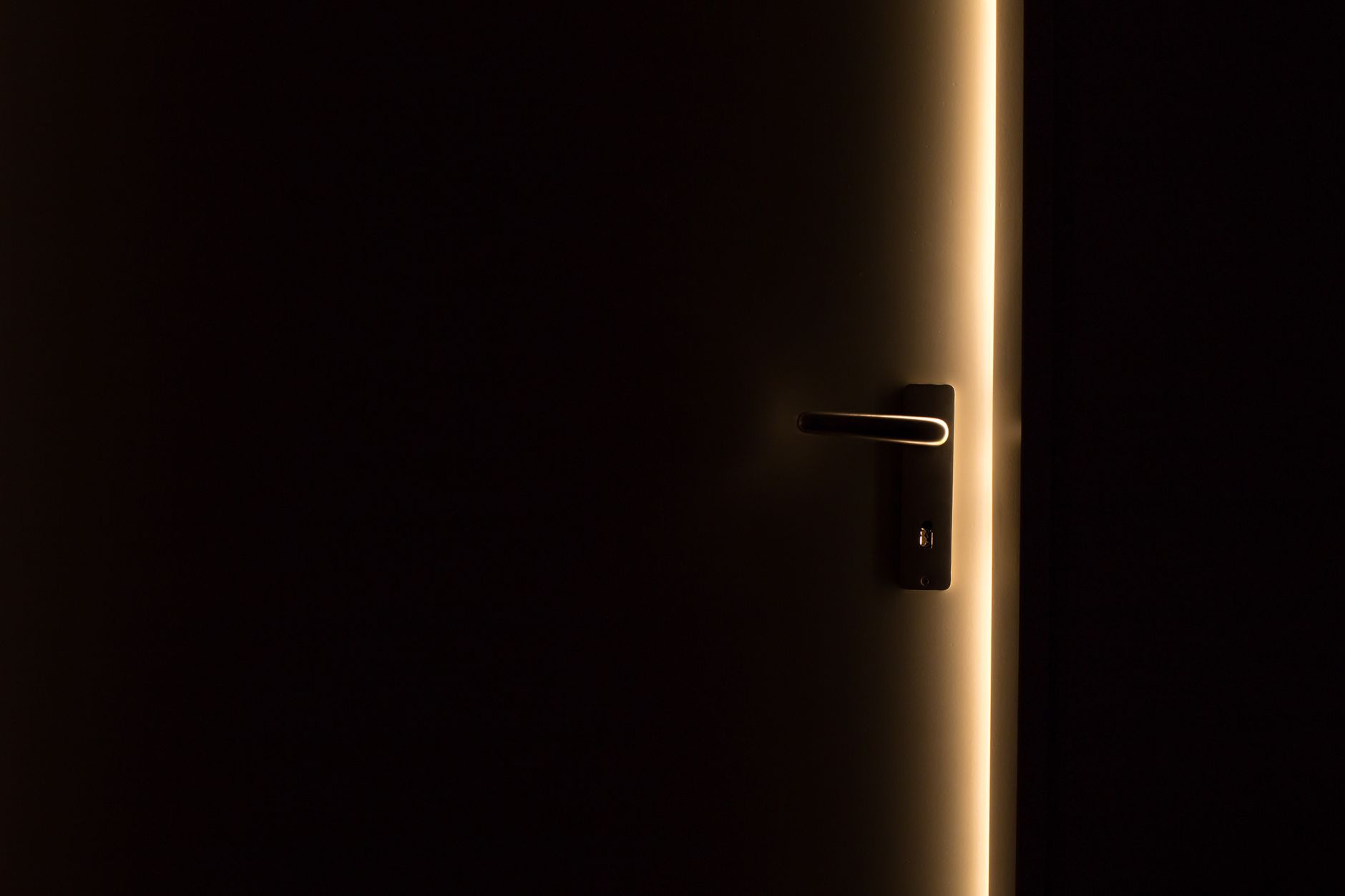 A figure standing in a doorway between dark and light spaces, representing the threshold practice of opening and closing the field cleanly to prevent unwanted influences.