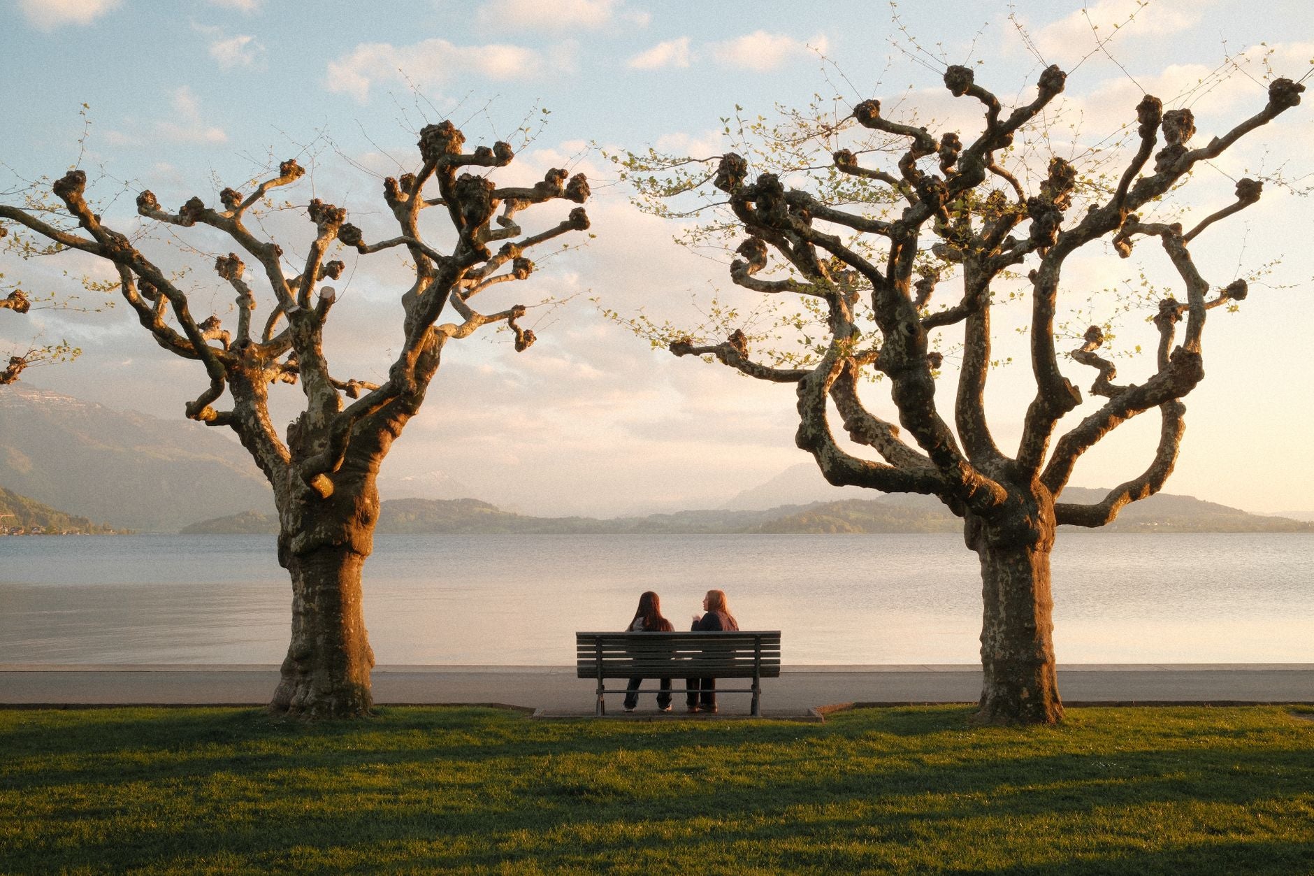 Two people sitting calmly at sunset over a lake, illustrating the inner-state baseline that field compatibility depends on