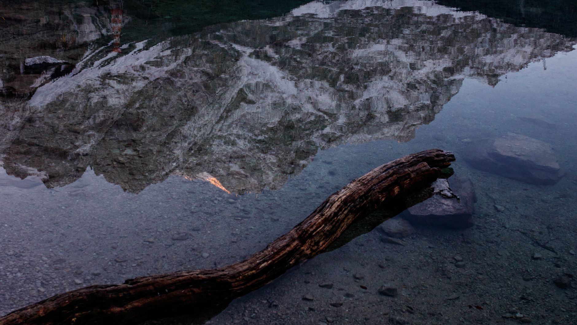 Serene mountain reflected in a calm lake with a weathered log in the foreground — illustration of inner stillness