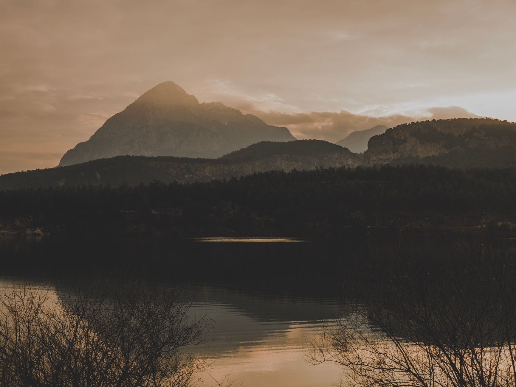 Quiet meditator at the edge of a still lake at dawn — effortless attention in deep practice