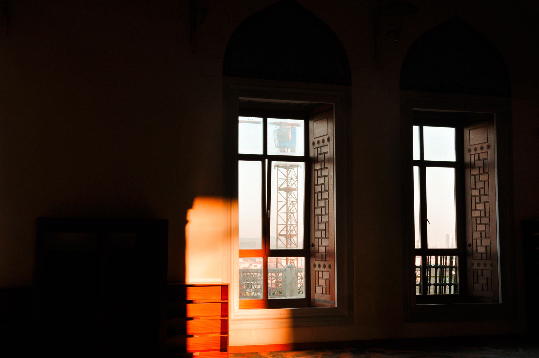 Sunlit room with decorative windows looking out on a city — illustration of openness and quiet space